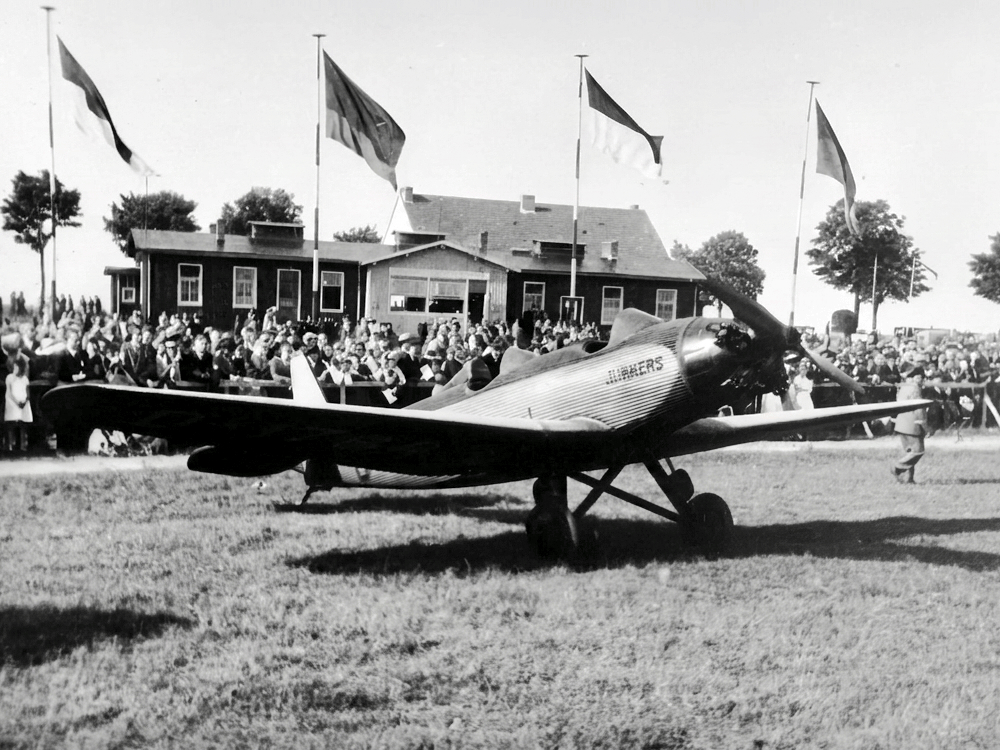 Eine Junkers Junior am Eröffnungstag (Foto: Archiv Forschungsflugplatz Würselen-Aachen GmbH, SW-Original und Farbversion des Bildes KI-bearbeitet)
