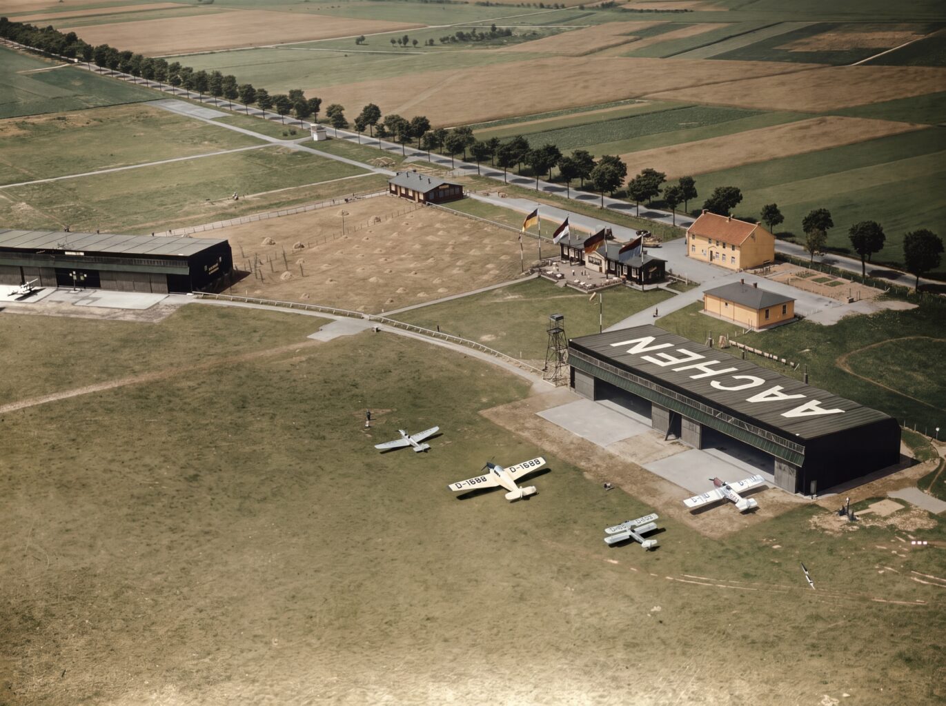 Merzbrück aus der Luft im Jahr 1931 (Foto: Stadtarchiv Aachen Foto 61-763 SW-Original und Farbversion des Bildes KI-bearbeitet)