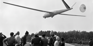 Zur aerodynamischen Optimierung der Tragflächenoberfläche haben die Konstrukteure auf klassische Bremsklappen verzichtet und die HKS3 mit einem Bremsfallschirm ausgestattet – ein Novum im Segelflugzeugbau. Hinter der Tragfläche am Rumpf gut zu erkennen: Lüftungsschlitze, die für einen steten Unterdruck im Innern sorgen und so ebenfalls den Luftwiderstand außen reduzieren. (Foto: Luftsportverein Aachen. SW-Original und Farbversion des Bildes KI-bearbeitet)